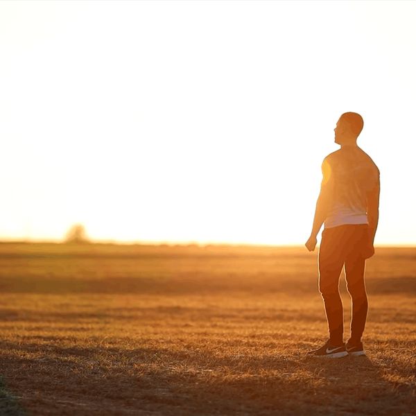 Silhouette of a person meditating against a calm, warm background.